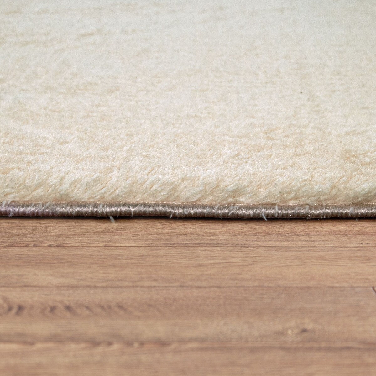 Tapis doux et lavable avec envers antidérapant, disponible en couleurs unies.